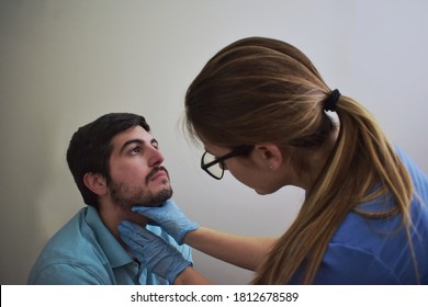 Healthcare worker palpating patient’s neck during exam