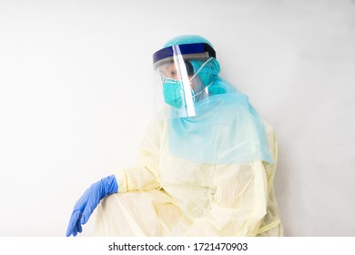 Healthcare Worker In Personal Protective Worker (PPE) Sit Down And Take A Nap Because Of Tired And Burnout. 