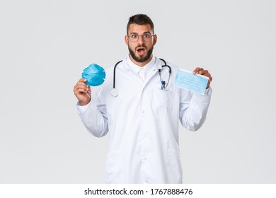 Healthcare workers, medical insurance, pandemic and covid-19 concept. Excited male doctor in glasses and white coat, physician showing medical mask and respirator, gasping amazed - Shutterstock ID 1767888476