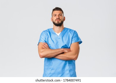 Healthcare Workers, Medicine, Covid-19, Pandemic Self-quarantine Concept. Confident Strong, Serious-looking Hispanic Doctor, Male Nurse In Blue Scrubs, Cross Hands Chest Self-assured, Save Patients