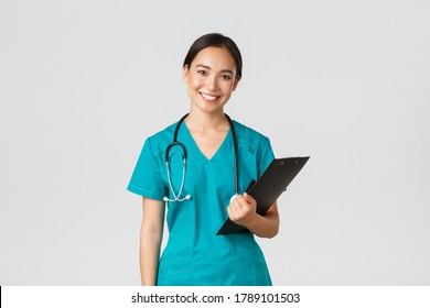 Healthcare workers, preventing virus, quarantine campaign concept. Smiling asian female nurse, doctor with clipboard wearing scrubs, provide checkup, examine patient in clinic, white background