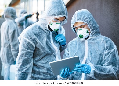 Healthcare Workers Wearing Hazmat Suits Working Together To Control An Outbreak