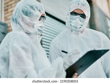 Healthcare Workers Wearing Protective Hazmat Suits Writing A Medical Report About Covid Cases Or Statistics. First Responders Filling In A Form After Doing A Safety Health Check For Coronavirus