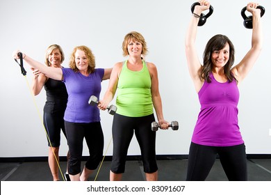 Healthy, Active Group Of Mature Women Working Out With Various Equipment At A Gym.