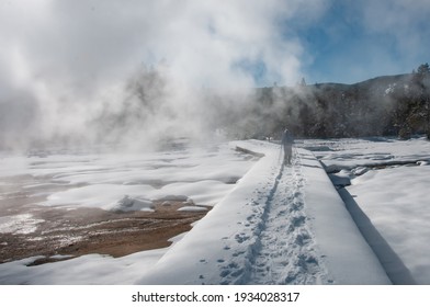 Healthy, Active Seniors Snowshoeing In Yellowstone National Park. Man Snowshoeing Through The Mist From A Geyser. Winter Snow Landscape. Snowshoes. Active Lifestyle. Wyoming.