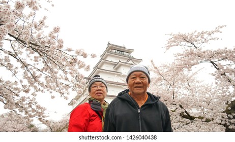 A Healthy Adult Couple With Japanese Castle And Full Blooming Cherry Blossom Background In Spring Time Of Japan 