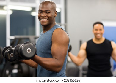 Healthy African Man Working Out With Dumbbells In Gym