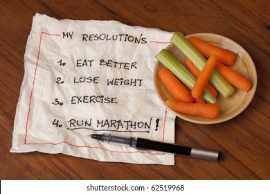 Healthy And Ambitious  New Year Resolutions (diet, Lose Weight, Exercise, Run Marathon) - Napkin Handwriting With Baby Carrot And Celery Snacks On Wooden Table