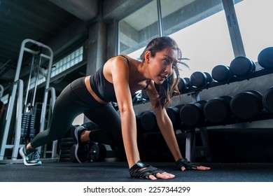 Healthy Asian athlete woman do running plank workout exercise body weight lifting at fitness gym. Attractive girl do body muscle building weight training at sport club. Health care motivation concept - Powered by Shutterstock