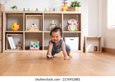 Healthy asian baby toddler crawling on floor to learn to crawl indoors. Adorable baby keeping her belly and legs down on the floor to belly crawl fun and happiness at home - Shutterstock ID 2176952881