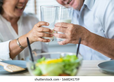 Healthy Asian Elderly Couple Enjoying Drinking Fresh Milk From Glass. Happy Smiling Senior Man And Woman Having Fun With Breakfast In The Morning. 