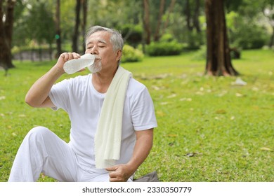 Healthy asian senior man drink water after practice yoga exercise tranining for healthy while looking at camera and smile in park outdoor. Happy elderly sport outdoor lifestyle concept - Powered by Shutterstock