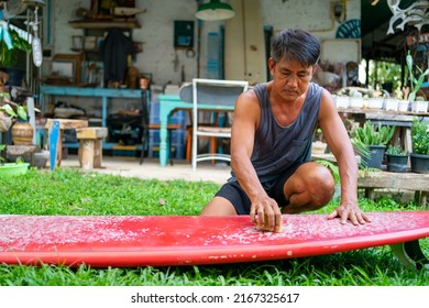 Healthy Asian senior man waxing surfboard surface at home. Active elderly male surfer enjoy outdoor lifestyle surfing at the sea on summer vacation. Retirement people activity and water sport concept. - Powered by Shutterstock