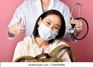 Healthy Asian Woman Backpacker Smiling With Doctor Showing Thumb Up In Hospital, Traveler And Tourist Worry Free Insurance, Doctor Screening Covid-19 Virus Disease Infected Patient.