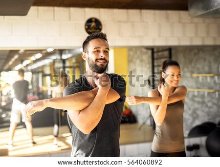 Healthy athletes exercising at gym.