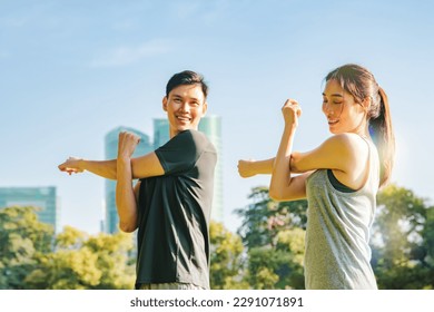 Healthy and attentive portrait asian couple doing sports warming up fitness stretching arms together in park lawn on sunny summer morning : Sports health care and recreational activities concept - Powered by Shutterstock