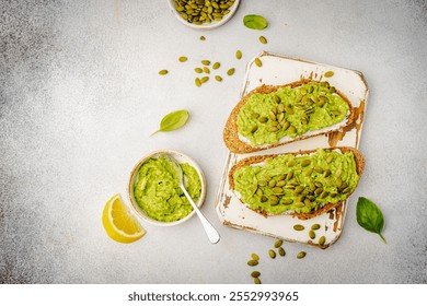 Healthy avocado toast for breakfast or lunch with whole grain bread and pumpkin seeds on a white table. Holistic nutrition concept. Health care, super food concept. top view - Powered by Shutterstock