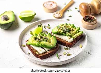 Healthy avocado toasts with rye bread, sliced avocado, cheese, pumpkin, nut and sesame for breakfast or lunch. Vegetarian food. Vegan menu. Food recipe background. Close up. - Shutterstock ID 2107144715