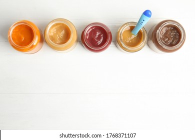 Healthy Baby Food In Jars On White Wooden Table, Flat Lay. Space For Text