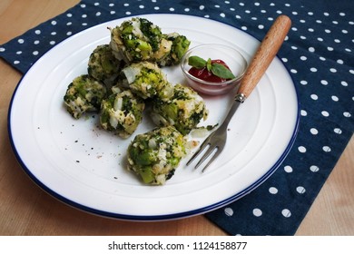 Healthy Baked Broccoli Tots With Ketchup And Basil (white Plate, Wooden Table, Wooden Fork, Blue And White Dot Placemat)