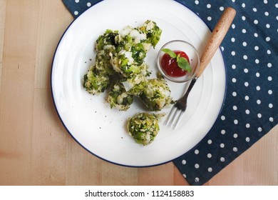 Healthy Baked Broccoli Tots With Ketchup And Basil (white Plate, Wooden Table, Wooden Fork, Blue And White Dot Placemat)