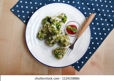 Healthy Baked Broccoli Tots With Ketchup And Basil (white Plate, Wooden Table, Wooden Fork, Blue And White Dot Placemat)