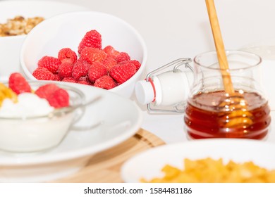 Healthy balanced Breakfast of cereals and dairy products with berries and honey on a white background. - Powered by Shutterstock