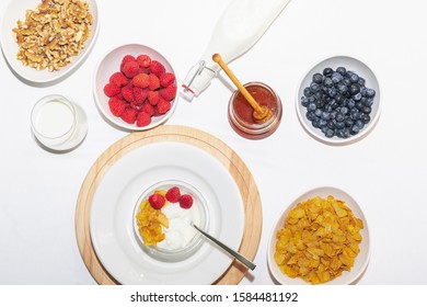 Healthy balanced Breakfast of cereals and dairy products with berries and honey on a white background. - Powered by Shutterstock