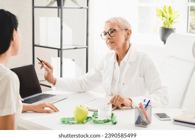 Healthy balanced dieting eating. Nutritionist dietitian explaining to female patient weight loss nutrition. Mockup laptop screen