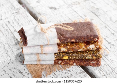 Healthy bars with nuts, seeds and dried fruits on the rustic white wood table background, with copy space. - Powered by Shutterstock