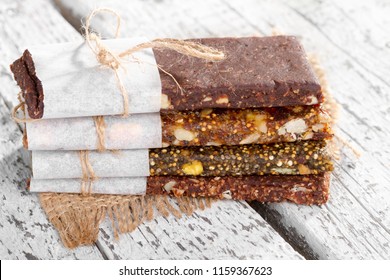 Healthy bars with nuts, seeds and dried fruits on the rustic white wood table background, with copy space. - Powered by Shutterstock