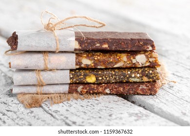 Healthy bars with nuts, seeds and dried fruits on the rustic white wood table background, with copy space. - Powered by Shutterstock