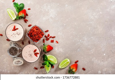 Healthy blended drink. Organic vegan non dairy smoothie with strawberry and goji berries, chia seeds and lime. Gray background with copy space. Top view - Powered by Shutterstock