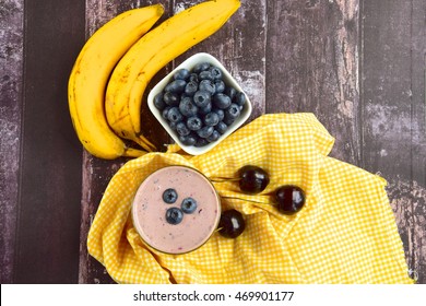 Healthy Blueberry Cherry Banana Smoothie. Wooden Background