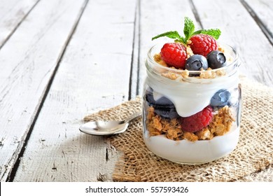 Healthy blueberry and raspberry parfait in a mason jar on a rustic white wood background - Powered by Shutterstock