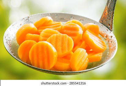 Healthy Boiled Or Steamed Crinkle Cut Sliced Farm Fresh Carrots In A Kitchen Ladle Ready To Be Served As An Accompaniment To A Meal