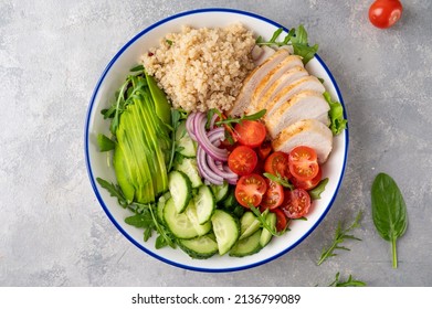 Healthy bowl lunch with grilled chicken, quinoa, avocado, tomatoes, cucumbers and fresh arugula on gray background. Top view. Selective focus - Powered by Shutterstock