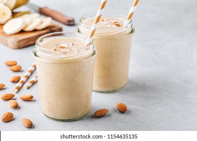 Healthy breakfast. Banana almond smoothie with cinnamon and oat flakes and coconut milk in glass jars - Powered by Shutterstock