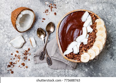 Healthy Breakfast Bowl. Chocolate Banana Smoothie Bowl With Coconut Flakes, Granola, Banana Slices. Top View, Flat Lay, Overhead