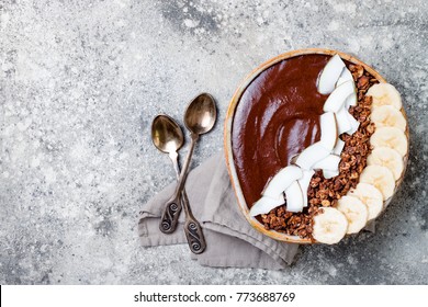 Healthy Breakfast Bowl. Chocolate Banana Smoothie Bowl With Coconut Flakes, Granola, Banana Slices. Top View, Flat Lay, Overhead