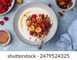 Healthy breakfast. Bowl with Greek yogurt, granola, raspberries, cherries and nuts. Healthy eating concept. Top view