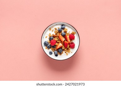 Healthy breakfast bowl with ingredients granola fruits Greek yogurt and berries on a pink background top view. Weight loss, healthy lifestyle and eating concept - Powered by Shutterstock