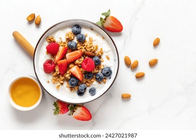 Healthy breakfast bowl with ingredients granola fruits Greek yogurt and berries on white marble table top view. Weight loss, healthy lifestyle and eating concept - Powered by Shutterstock