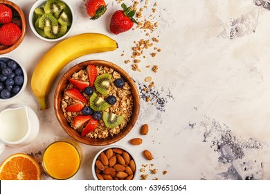 Healthy Breakfast - Bowl Of Muesli, Berries And Fruit, Nuts, Orange Juice, Milk, Top View.