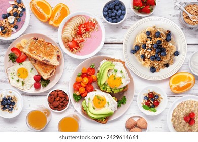 Healthy breakfast or brunch table scene on a white wood background. Overhead view. Avocado toast, smoothie bowls, oats, yogurt and assorted nutritious foods. - Powered by Shutterstock