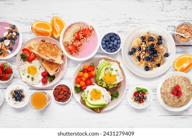 Healthy breakfast or brunch table scene on a white wood background. Top down view. Avocado toast, smoothie bowls, oats, yogurt and a variety of nutritious foods. - Powered by Shutterstock