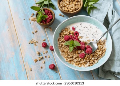 Healthy breakfast cereal bowl homemade granola with fresh raspberry and chia seeds on a rustic table. Diet nutrition concept.  Copy space.  - Powered by Shutterstock