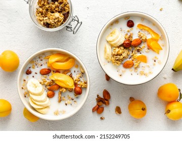 Healthy breakfast cereal top view. Granola breakfast with fruits, nuts, milk and peanut butter in bowl on a white background - Powered by Shutterstock