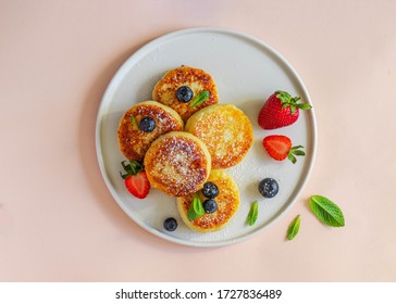 Healthy Breakfast Concept. Cheese Pancakes With Strawberry, Blueberry, Mint Leaf On White Ceramic Plate Searved On Pink Background. Calcium Vitamin Food. Flatlay With Copyspace. Close Up. 