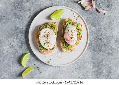 Healthy Breakfast Concept. Two Toast With Whole Grain Bread With Avocado Guacamole And  Poached Egg, Garlic And Lime. Healthy Lifestyle. Flatlay With Copyspace. Close Up 